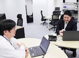 オフィス内で談笑する社員のお二人。わからないことはすぐに聞ける環境です◎